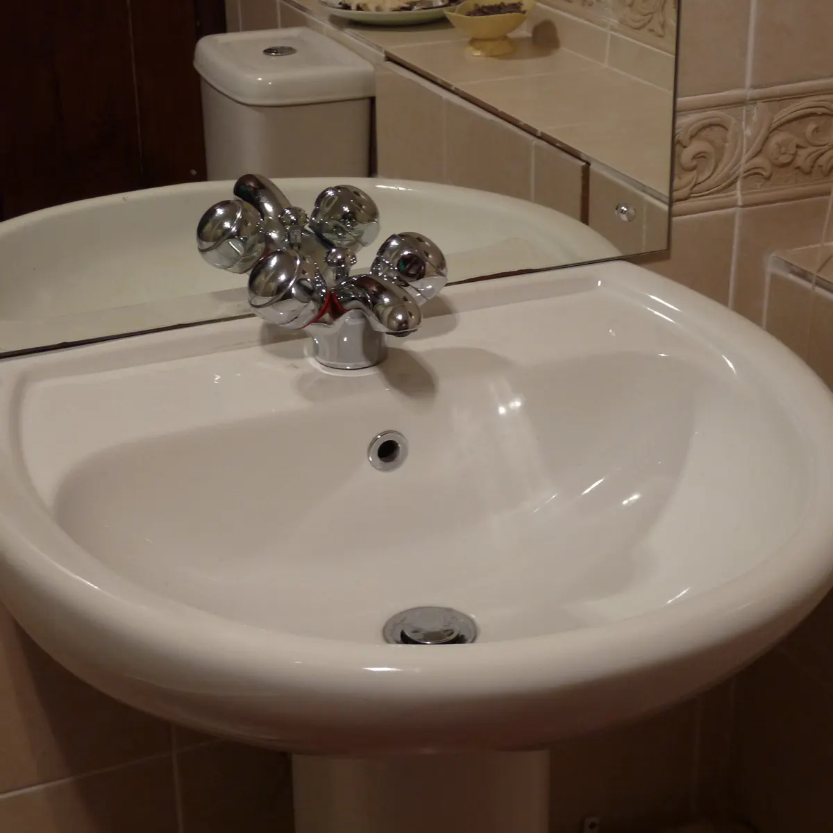 A clean white bathroom sink with a chrome tap