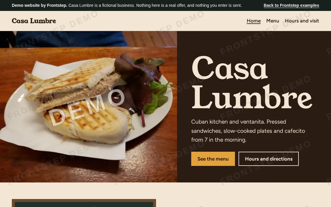 The home page of an example restaurant website, with a photo of a pressed sandwich, the restaurant name and buttons for the menu and directions.